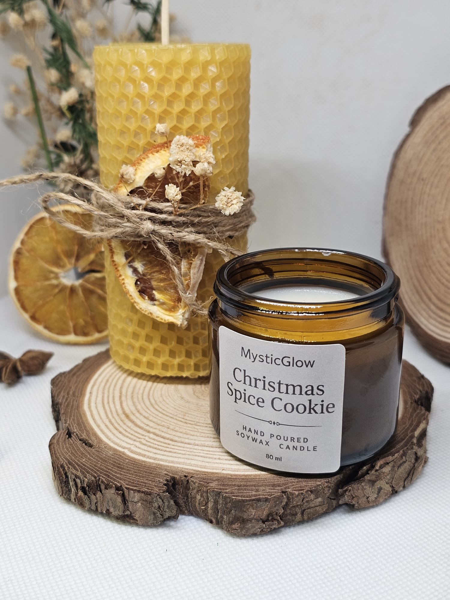 Rustic Christmas candle gift set featuring beeswax pillar candle and Christmas Spice Cookie candle arranged with cinnamon and dried citrus