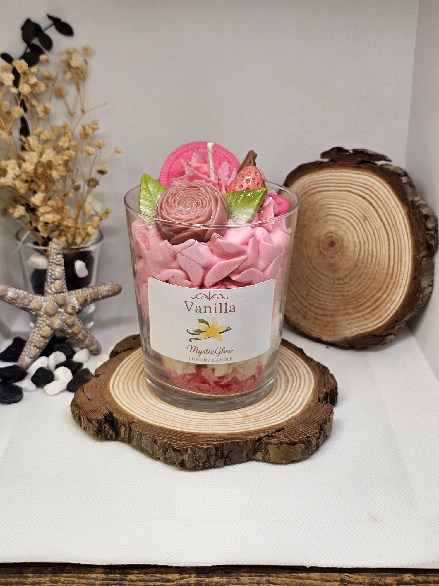 Vanilla candle with pink frosting design and wax strawberry on top