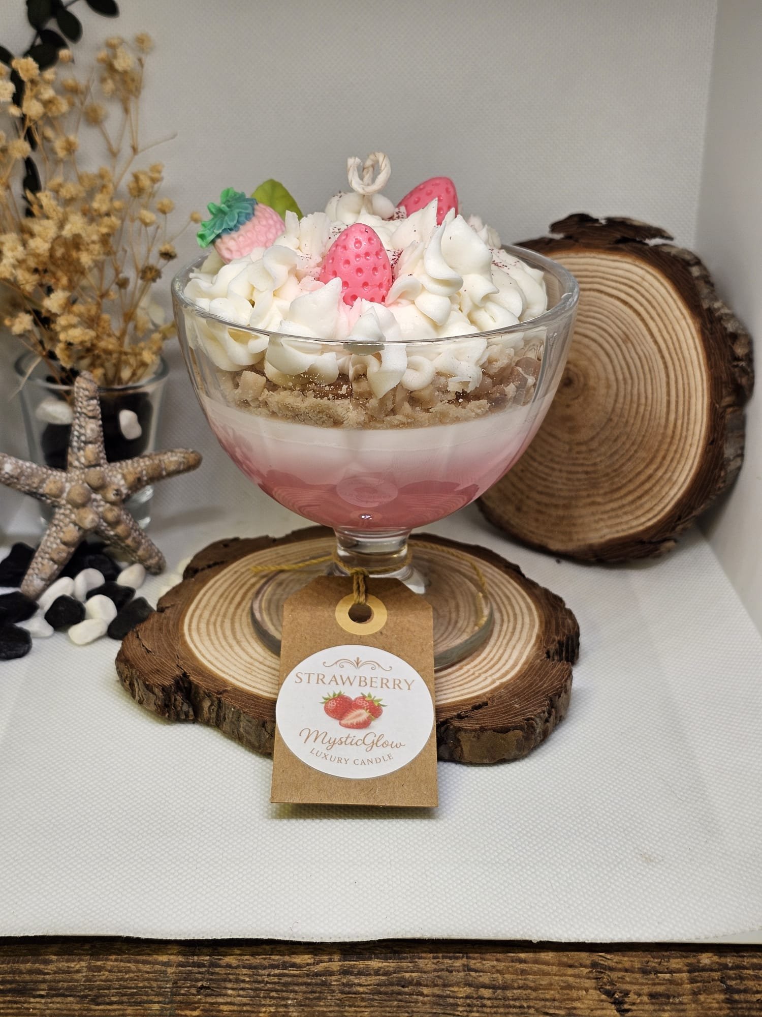 Handcrafted soy candle with pink base, whipped topping, and wax strawberries