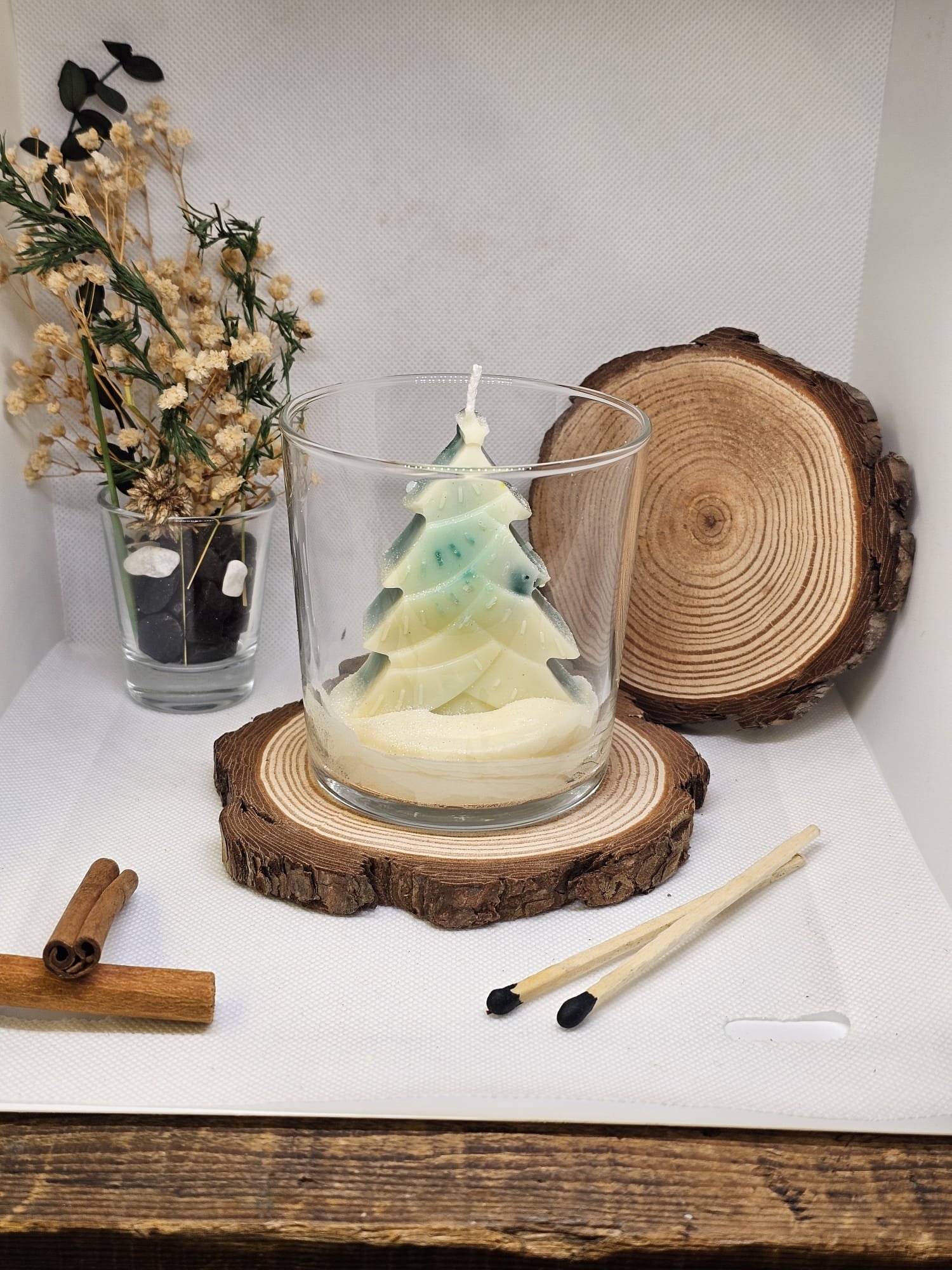 Hand-poured soy wax Christmas candle in glass jar with rustic home decor background