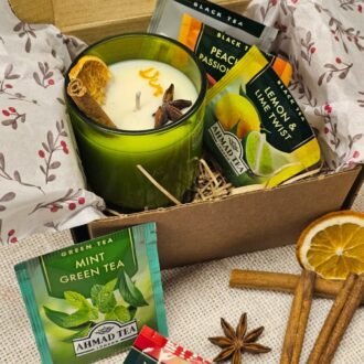MysticGlow candle and tea gift set featuring a handmade soy wax candle in a green glass jar, five assorted Ahmad Tea bags and rustic kraft gift packaging.