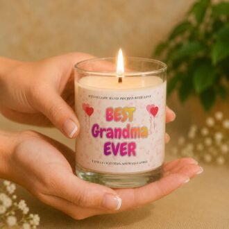 MysticGlow Best Grandma Ever scented soy wax candle held gently in hands with a glowing flame, featuring a colourful pink heart and balloon design. A lovely handmade gift for grandma on her birthday, Mother's Day or any special occasion.