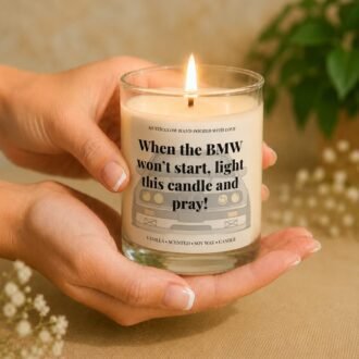 MysticGlow funny BMW scented soy wax candle held gently in hands with a glowing flame, featuring a BMW car illustration and humorous quote. A unique novelty gift for BMW drivers, car lovers and birthdays.
