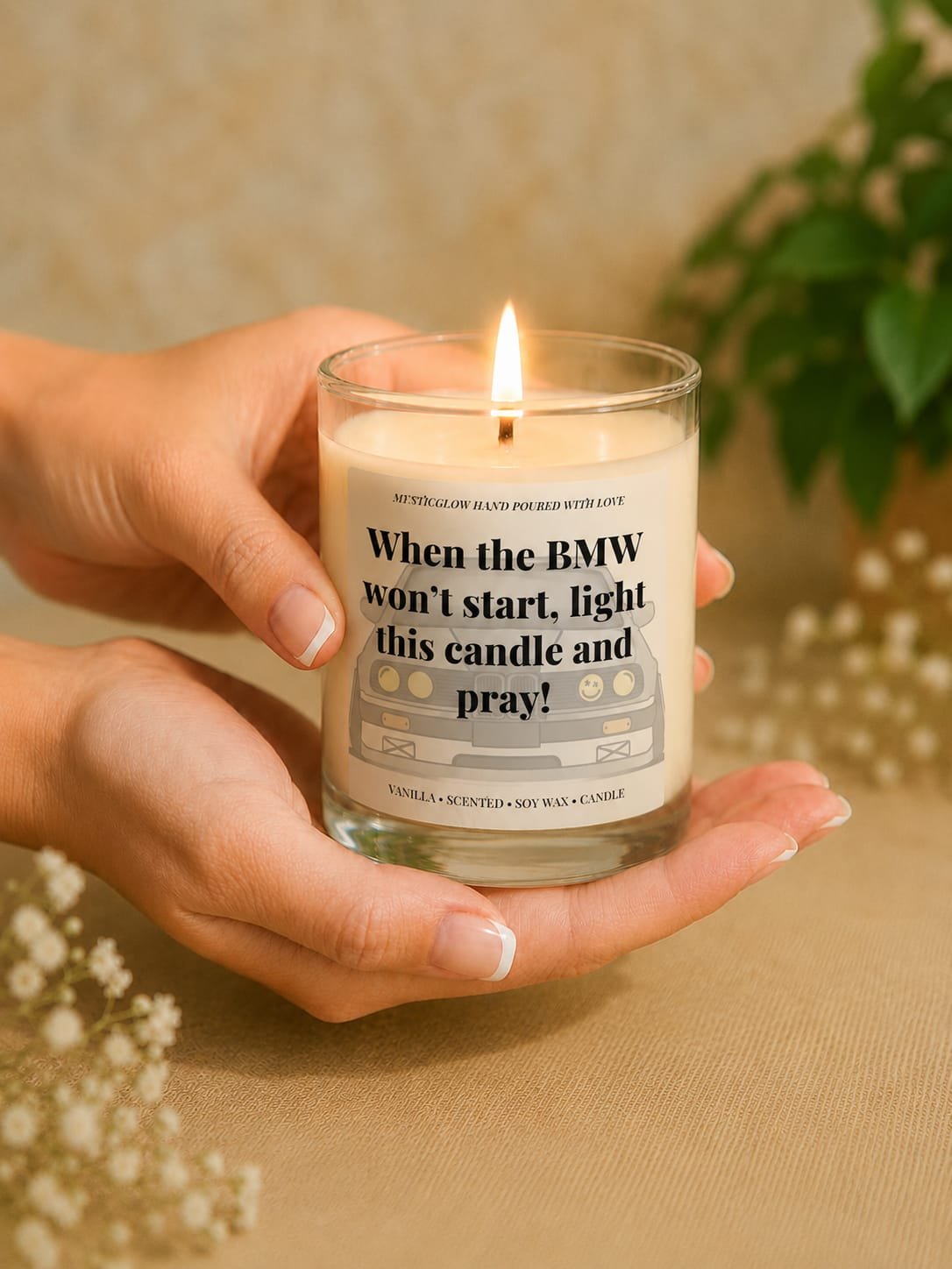 MysticGlow funny BMW scented soy wax candle held gently in hands with a glowing flame, featuring a BMW car illustration and humorous quote. A unique novelty gift for BMW drivers, car lovers and birthdays.